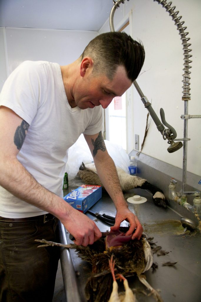 A man processing a pheasant.