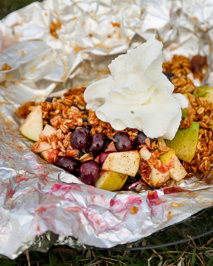 Dessert cooked by campfire: fresh fruit, granola and whipped cream.