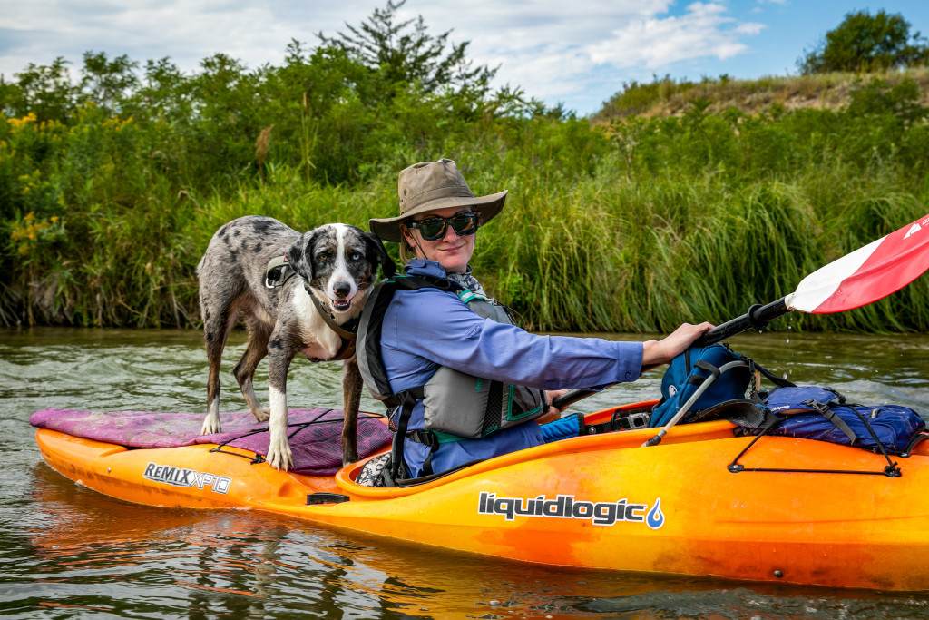 A woman kayaking with her dog.