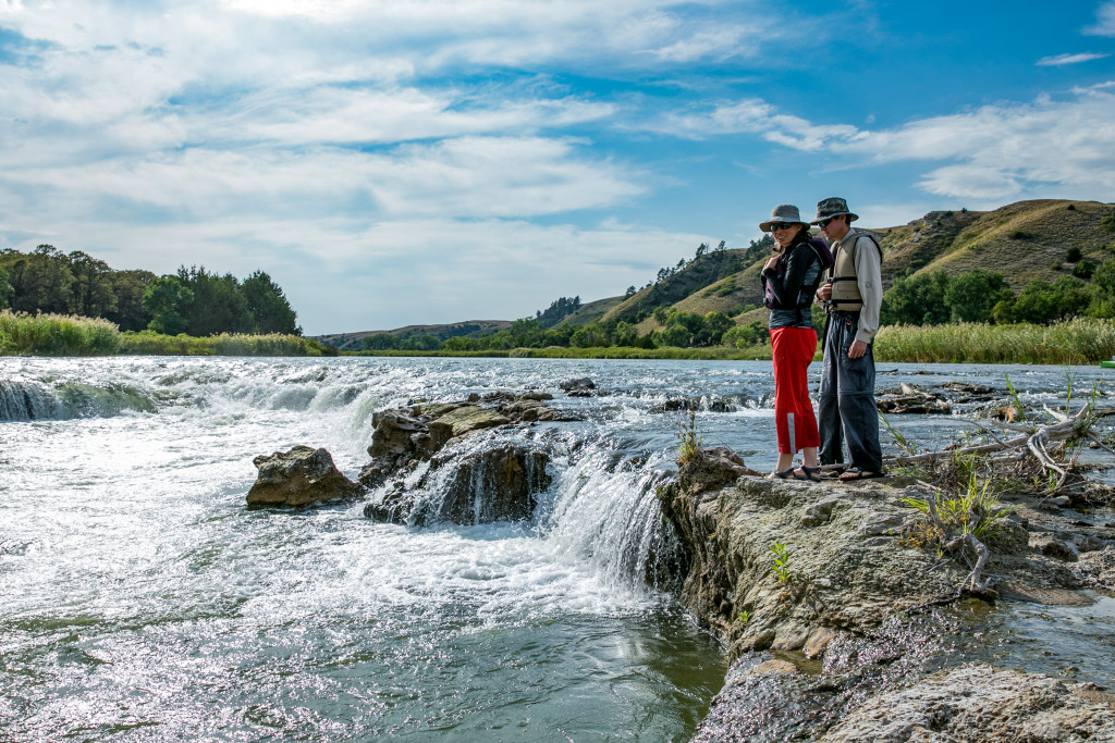 A man and woman inspecting a chute on the river.