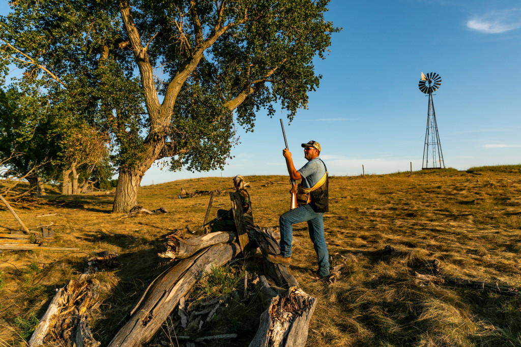 A man and woman dove hunting near a windmill.