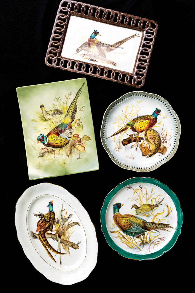 Five porcelain plates with scenes of pheasants painted on them.