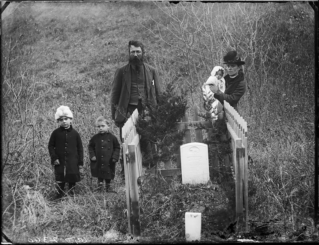 A family visits a grave on the Nebraska prairie in 1887.