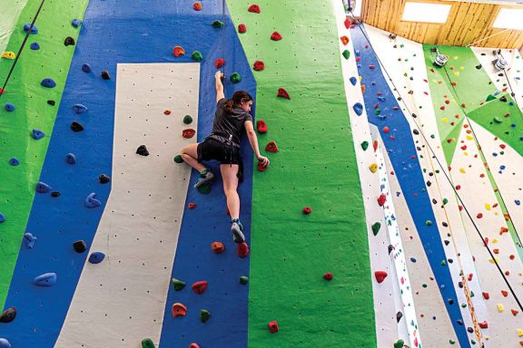 A girl climbing a rock wall.