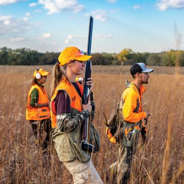 A female pheasant hunter being guided.