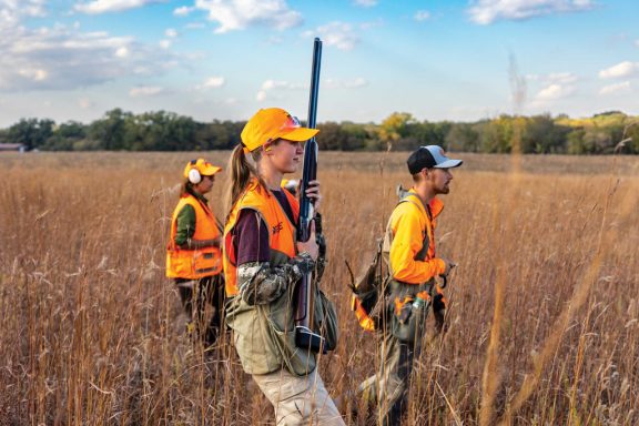 A female pheasant hunter being guided.