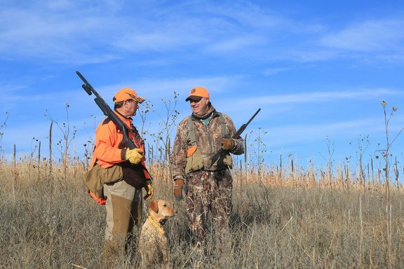 Two men and a dog upland hunting