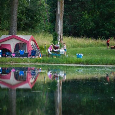 a family camps by a lake