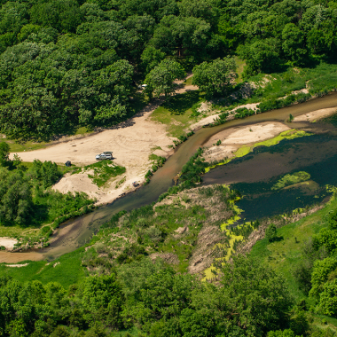 Aerial photo of a tree-lined creek during summer on a wildlife management area in Nebraska.