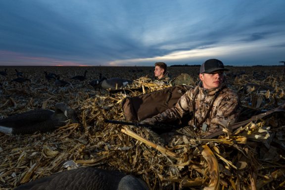 two high school kids in goose hunting in a cornfield