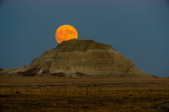 Full moon and Sugarloaf Butte