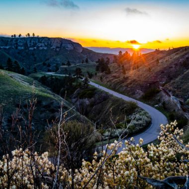 View overlooking a scenic canyon byway in a Nebraska state park as the sun sets in the background.