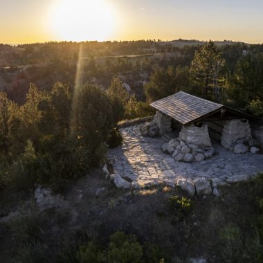 A stone picnic shelter on a hill.