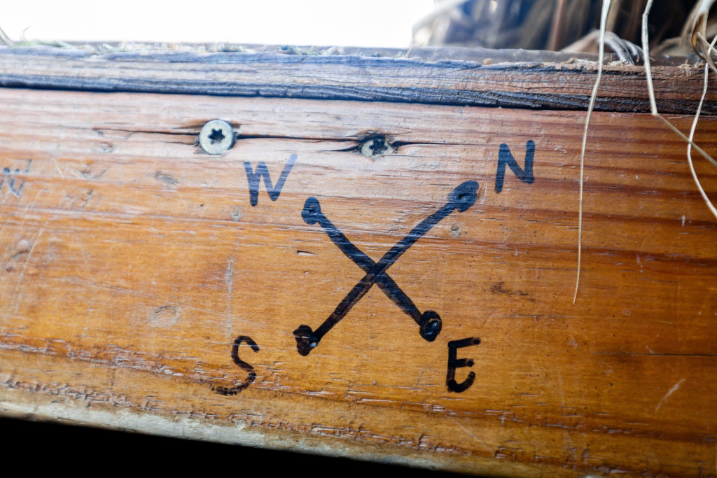 A compass is hand-drawn in black marker on a board