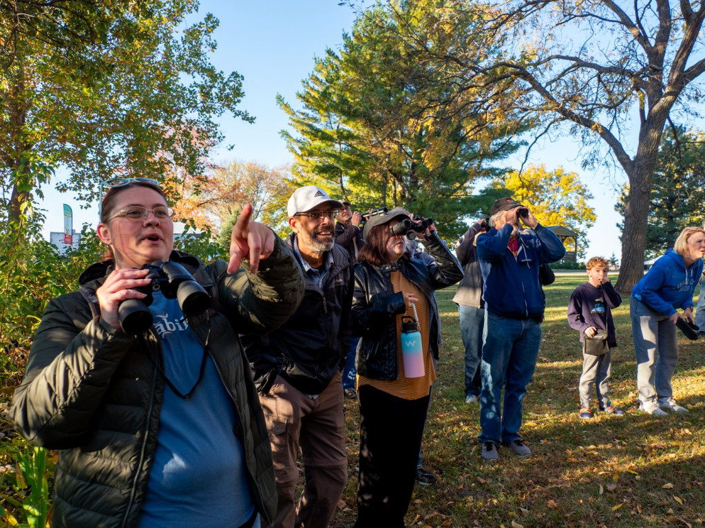 A group of people birding with binoculars.