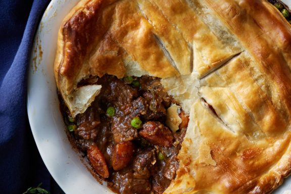 Venison and vegetable-filled pot pie with puff pastry.