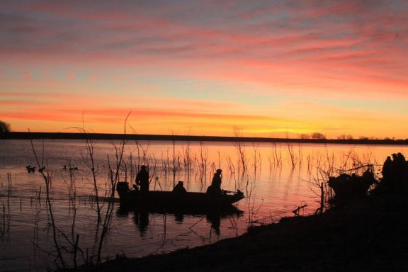 waterfowl hunters during sunrise.