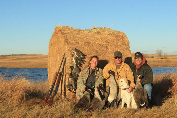 Two men and a woman waterfowl hunting.