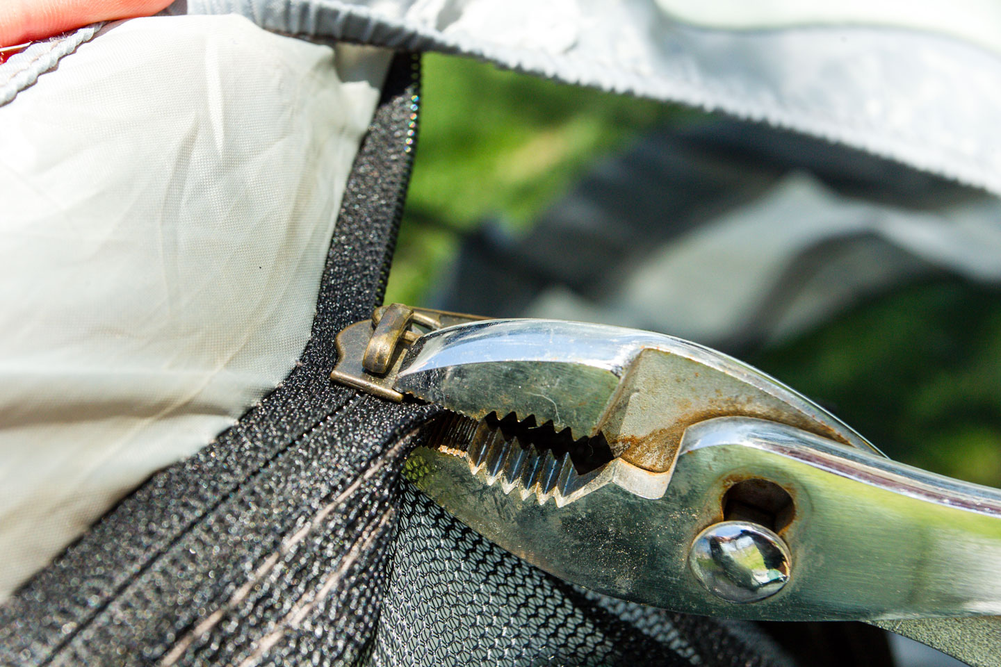 Pliers holds a tent zipper.