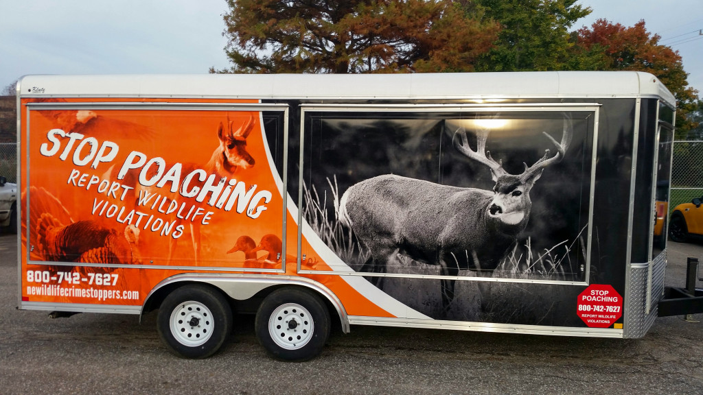 a picture of a trailer with 'Stop Poaching: Report Wildlife Violations" on it